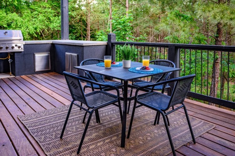 Four-chair patio table with orange juice, beside the built-in grill