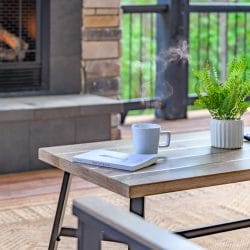 Coffee table with a mug and a book in front of the deck fireplace