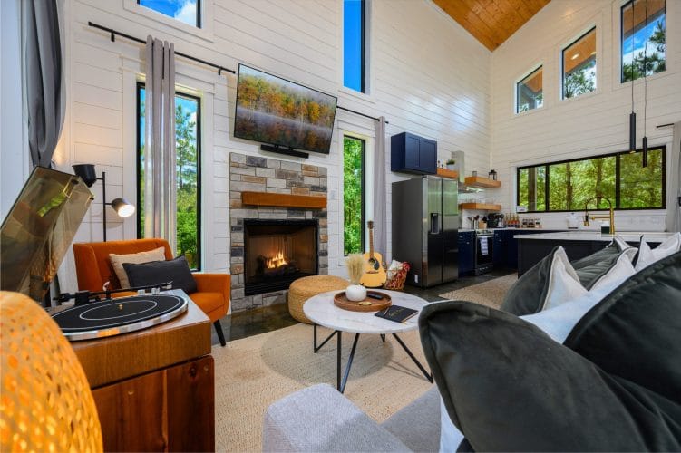 Living room with a record player, a gas fireplace under a TV and an orange chair
