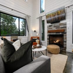 Sofa facing the fireplace and TV, an acoustic guitar standing by the window