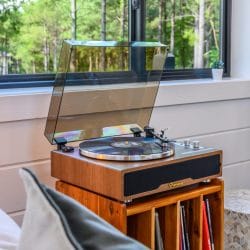 Record player on a wood console with a shelf of records