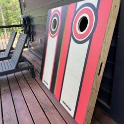 Cornhole boards leaning against the dark deck wall