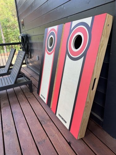 Cornhole boards leaning against the dark deck wall